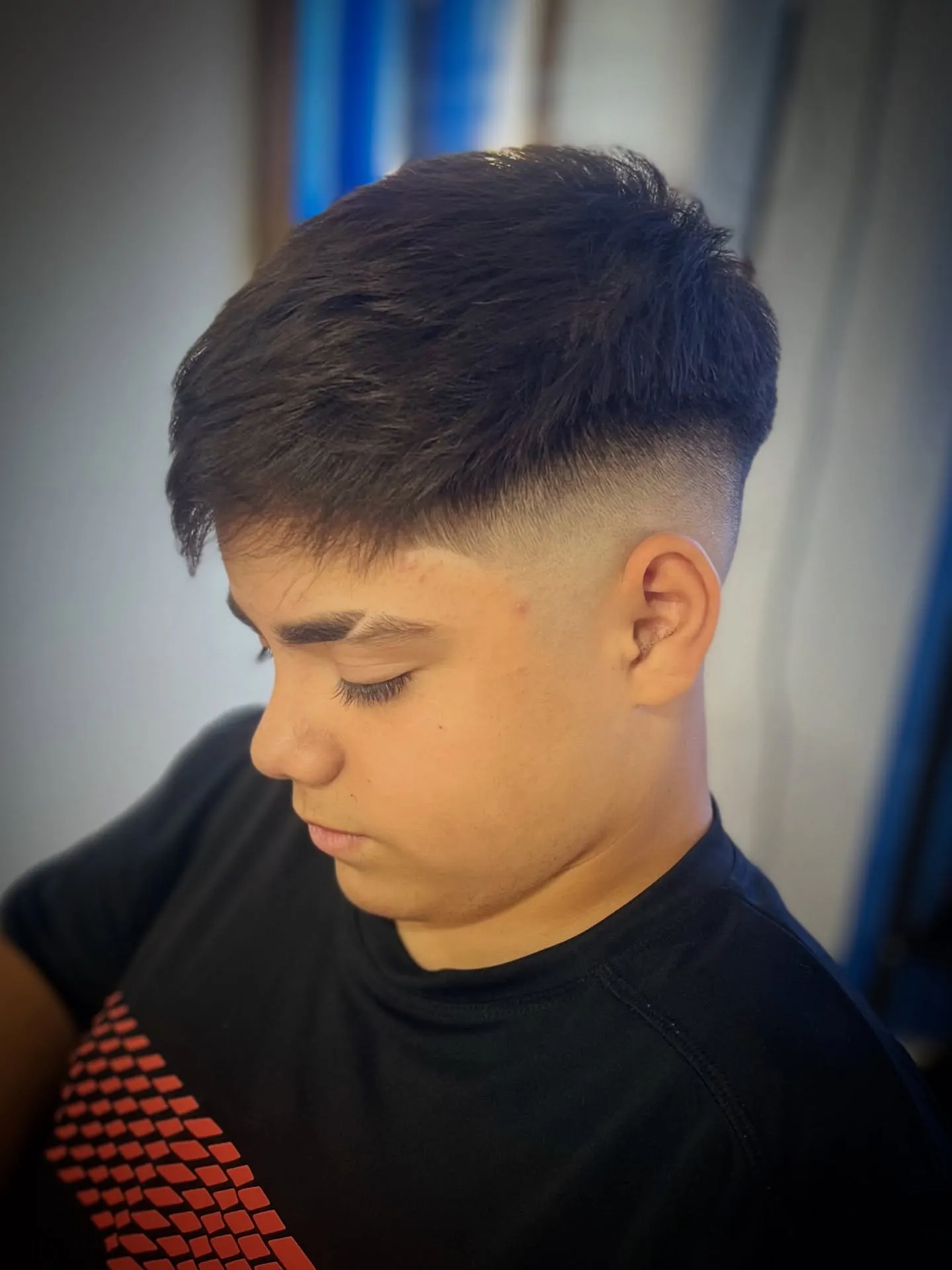 Corte masculino con fade visto desde arriba, peinado hacia adelante y degradado prolijo, en Chuks Barbería