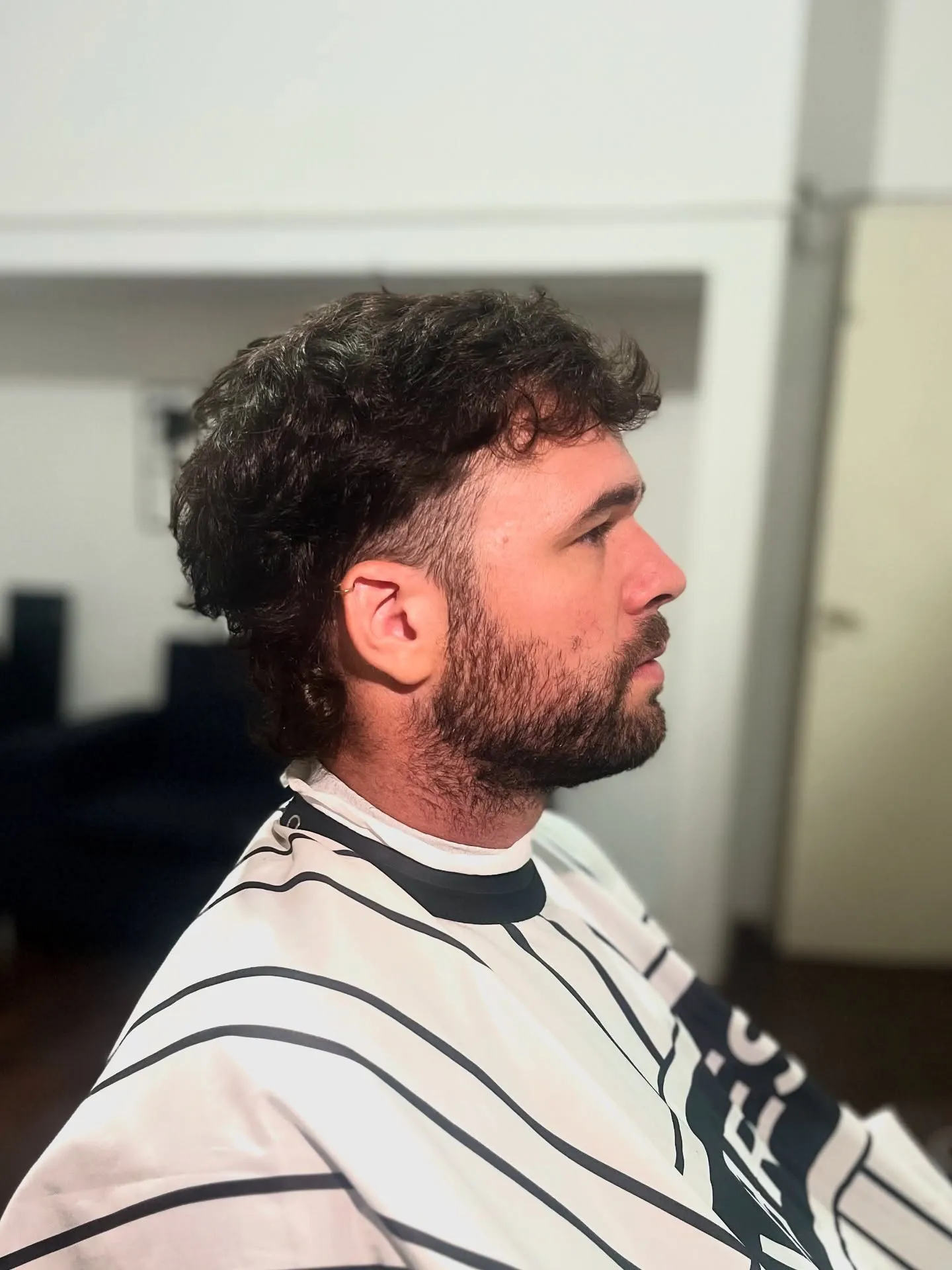 Cliente antes del corte, con el pelo largo y rizado, en Chuks Barbería